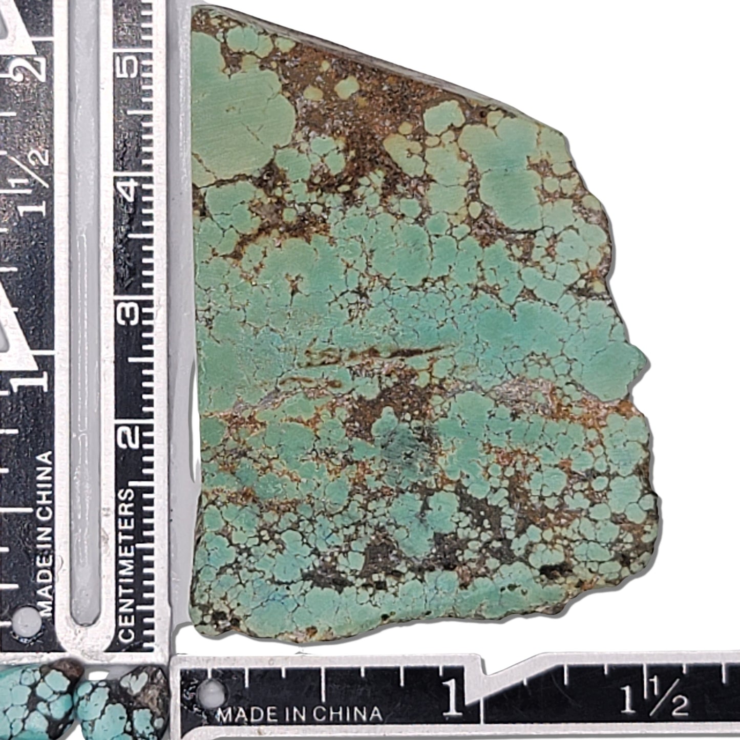 A 26-gram turquoise rough stone featuring a soft green hue with a delicate brown matrix. Approximate dimensions: 5.8 cm x 4.1 cm x 0.6 cm. Perfect for lapidary or custom jewelry design. Available at www.naturalturquoise.com.