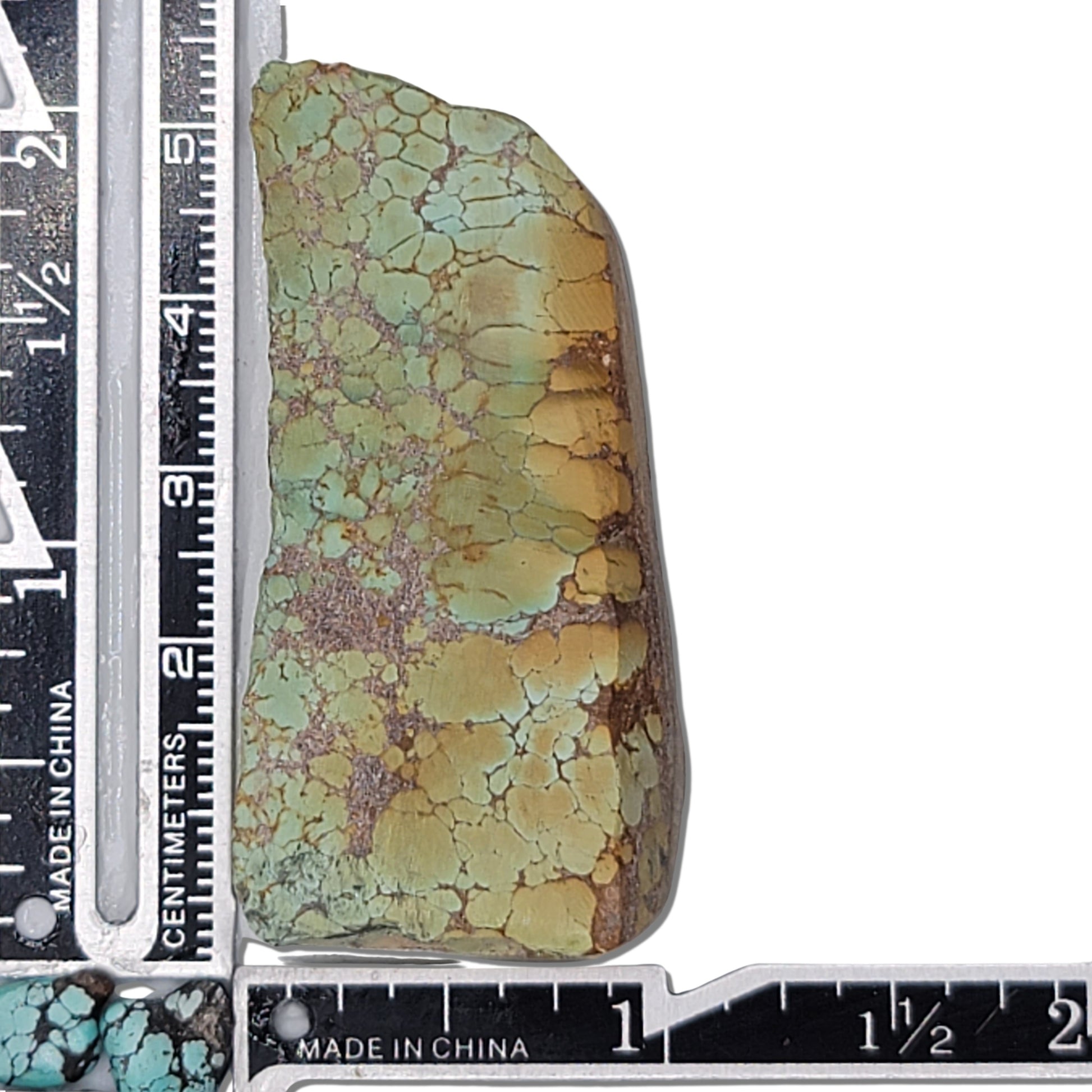 Natural rough turquoise stone with a mix of green and earthy brown matrix patterns, shown with measuring scale for size reference – high-quality turquoise for jewelry making available at NaturalTurquoise.com.