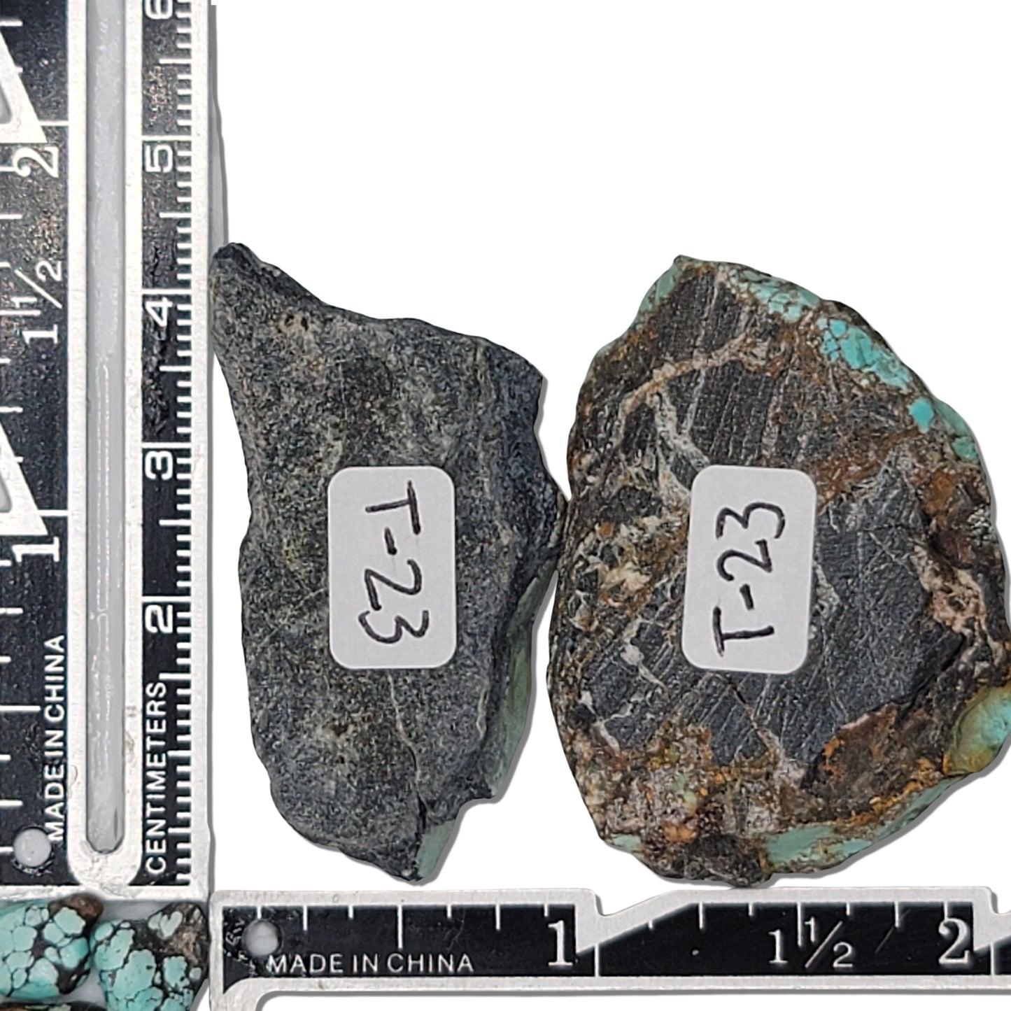 Two rough turquoise stones with greenish hues and dark matrix patterns, approx. 4 cm x 2 cm and 3.5 cm x 2.5 cm, www.naturalturquoise.com.