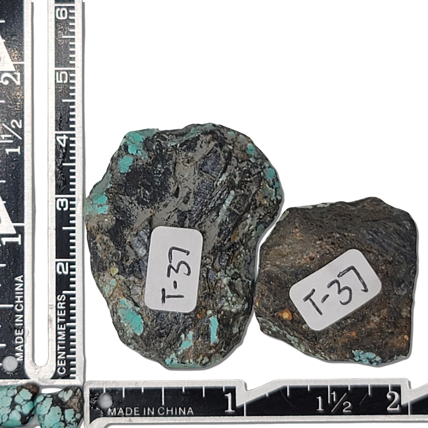 Two rough turquoise stones with green and blue hues and dark matrix, approx. 4 cm x 3 cm and 3 cm x 2.5 cm, www.naturalturquoise.com.