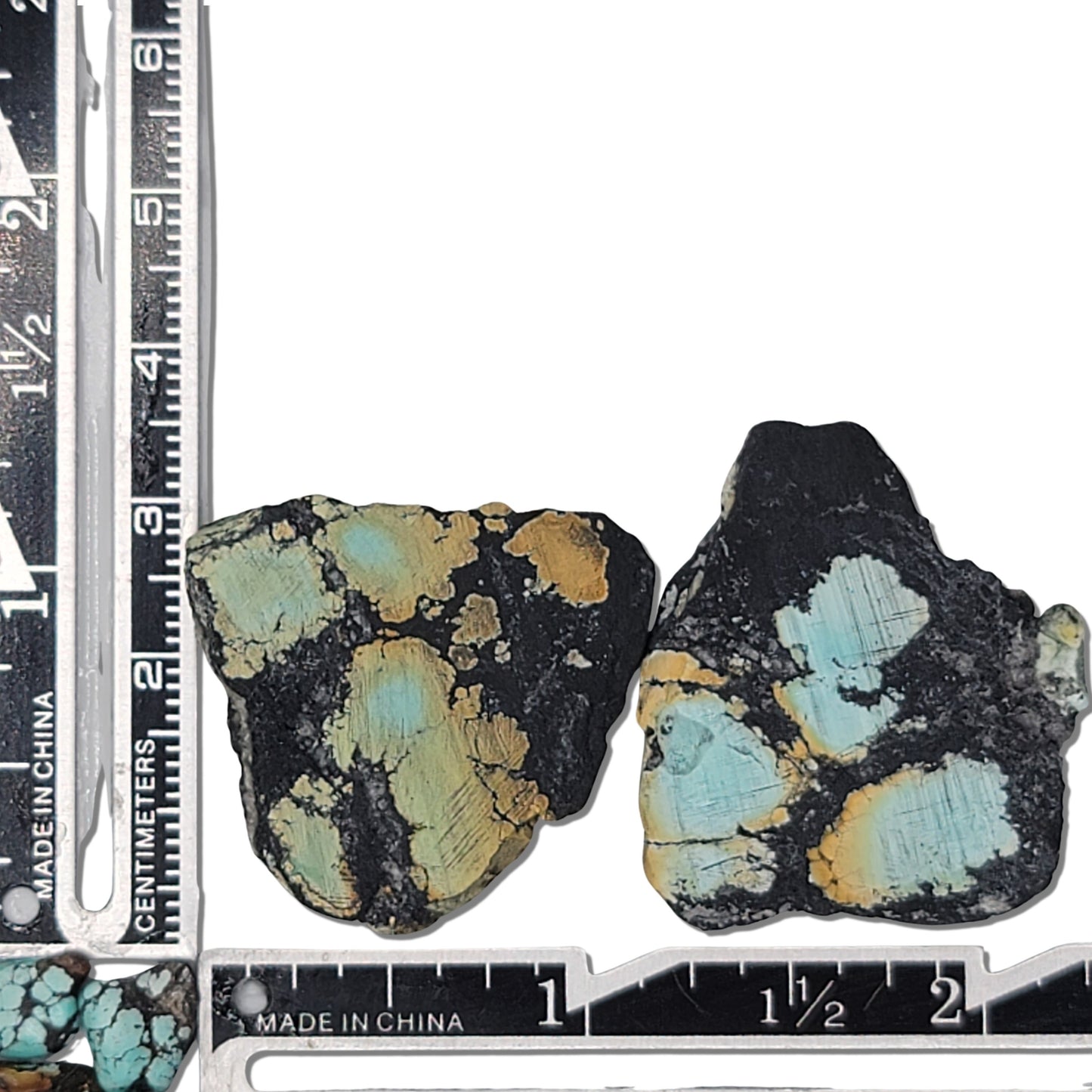 Two rough turquoise stones with black matrix and patches of light blue and earthy tones, approx. 3 cm x 3.5 cm and 3 cm x 3 cm, www.naturalturquoise.com.