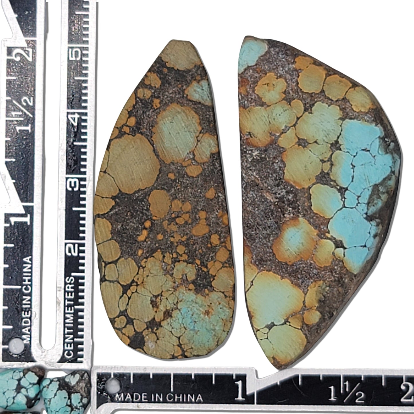 Pair of natural Hubei turquoise stones, 29g total, earthy tan, green, and blue hues with dark matrix, elongated shapes, approx. 5 cm x 2.5 cm each, www.naturalturquoise.com.