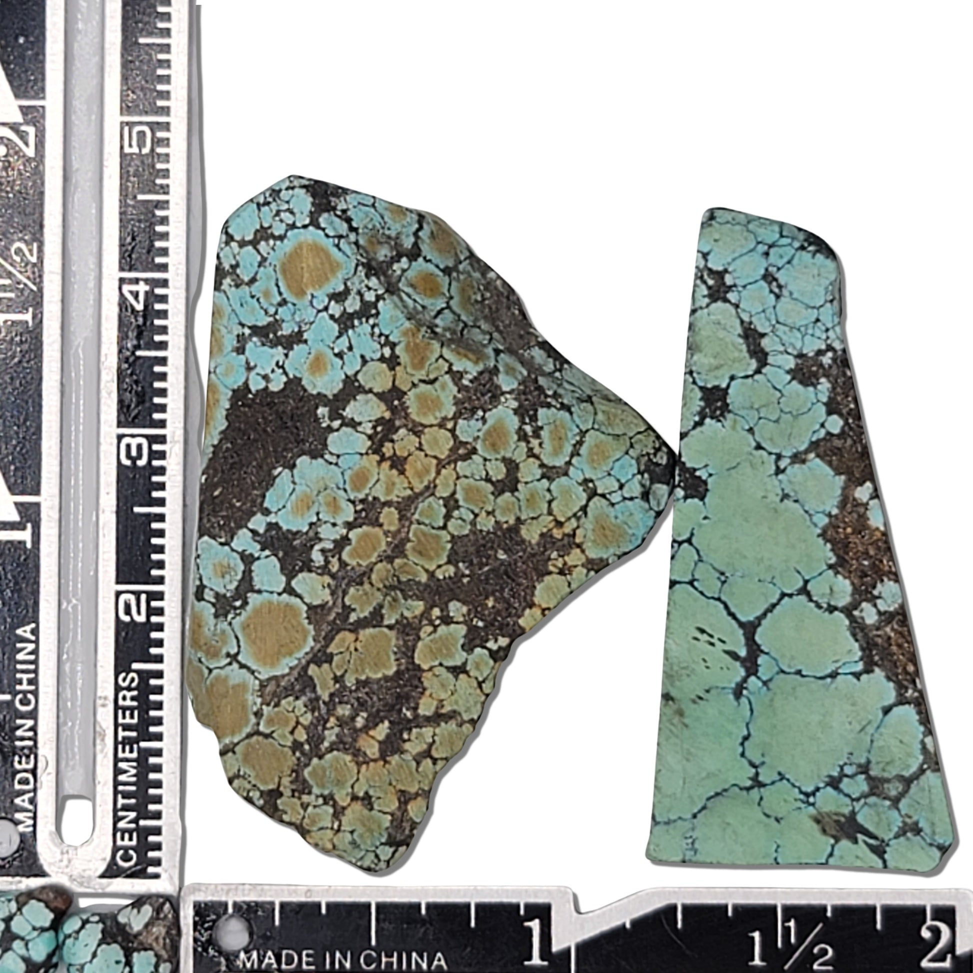 A pair of natural turquoise stones weighing 21 grams, featuring blue-green tones with golden and dark matrix patterns. The stones measure approximately 4.2 cm x 3.3 cm and 4.5 cm x 2 cm, displayed with a ruler for scale. Available for purchase at www.naturalturquoise.com, ideal for lapidary and jewelry projects.