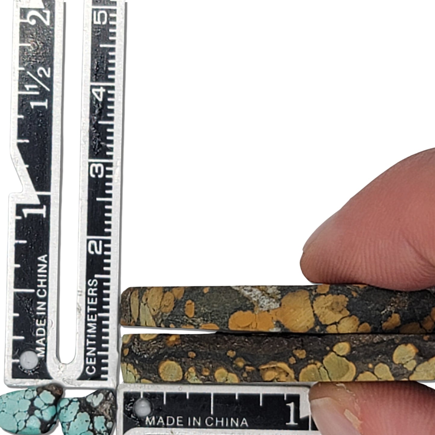 A pair of natural turquoise stones weighing 19 grams, featuring earthy golden tones with green highlights and bold dark matrix patterns. The stones measure approximately 4.5 cm x 2 cm and 4 cm x 2.3 cm, displayed with a ruler for scale. Available for purchase at www.naturalturquoise.com, ideal for lapidary and jewelry projects.