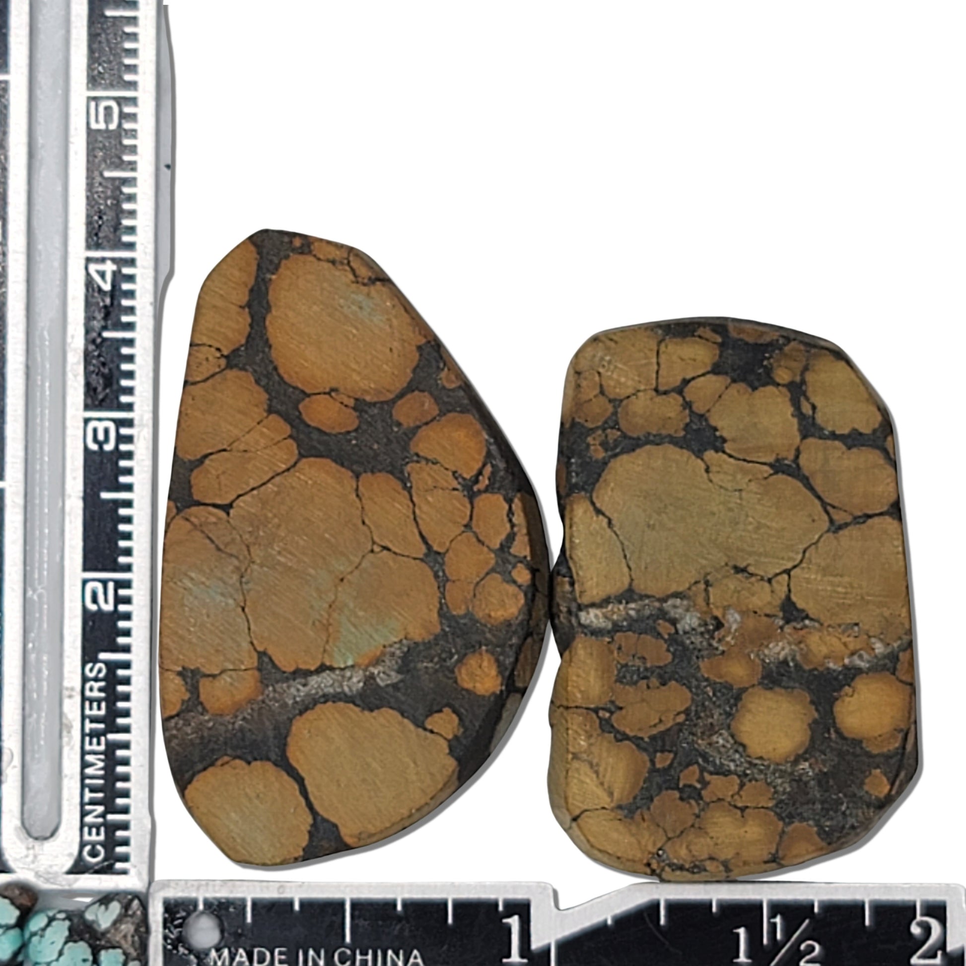 A pair of natural turquoise stones weighing 20 grams, featuring rich golden hues and bold dark matrix patterns. The stones measure approximately 4.2 cm x 3 cm and 3.8 cm x 2.8 cm, displayed with a ruler for scale. Available for purchase at www.naturalturquoise.com, ideal for jewelry making and lapidary projects.