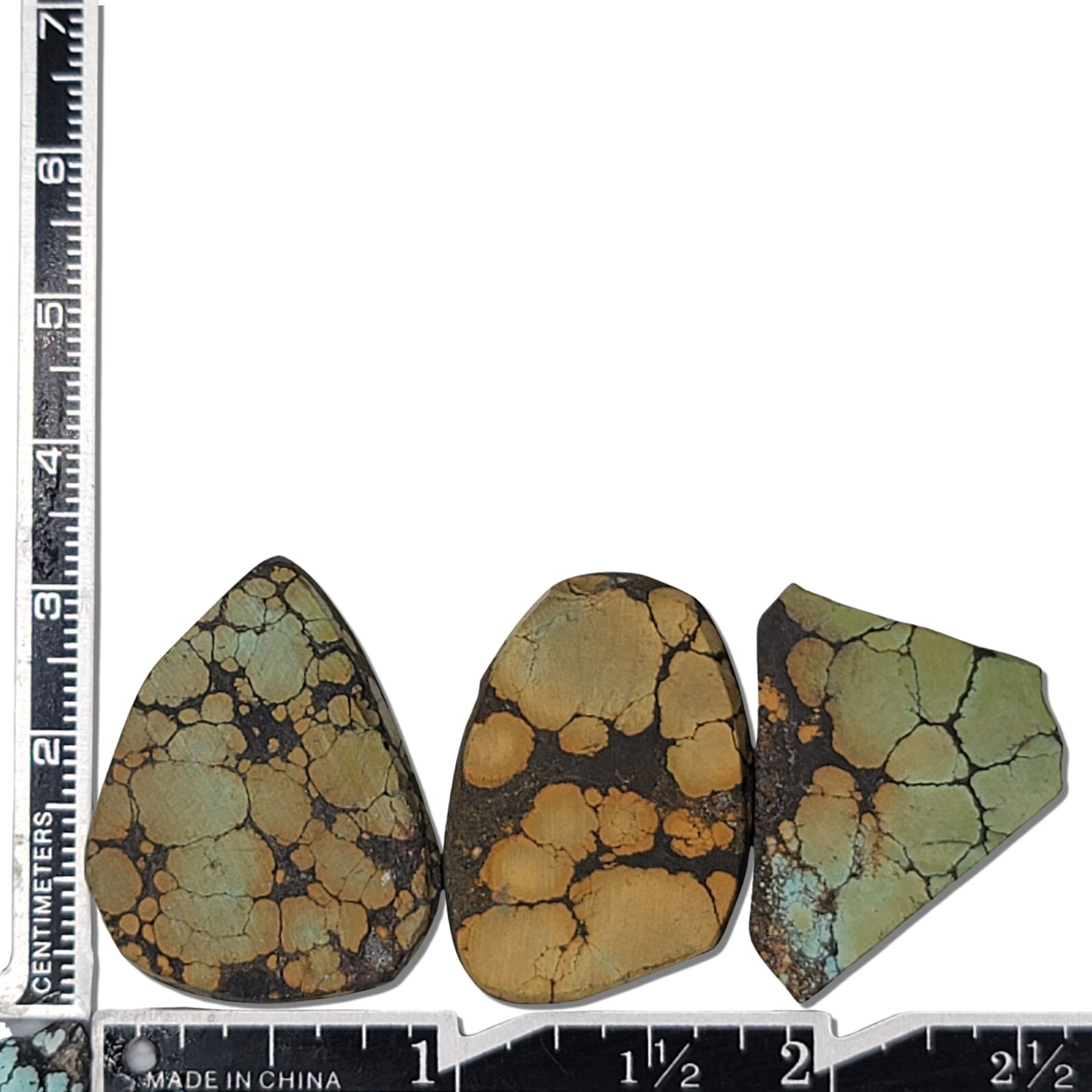 A natural turquoise stone triplet weighing 18 grams, featuring earthy golden and green tones with bold dark matrix patterns. The stones measure approximately 4 cm x 3 cm, 3.8 cm x 2.7 cm, and 3.5 cm x 2.5 cm, displayed with a ruler for scale. Available for purchase at www.naturalturquoise.com, ideal for lapidary and jewelry projects.