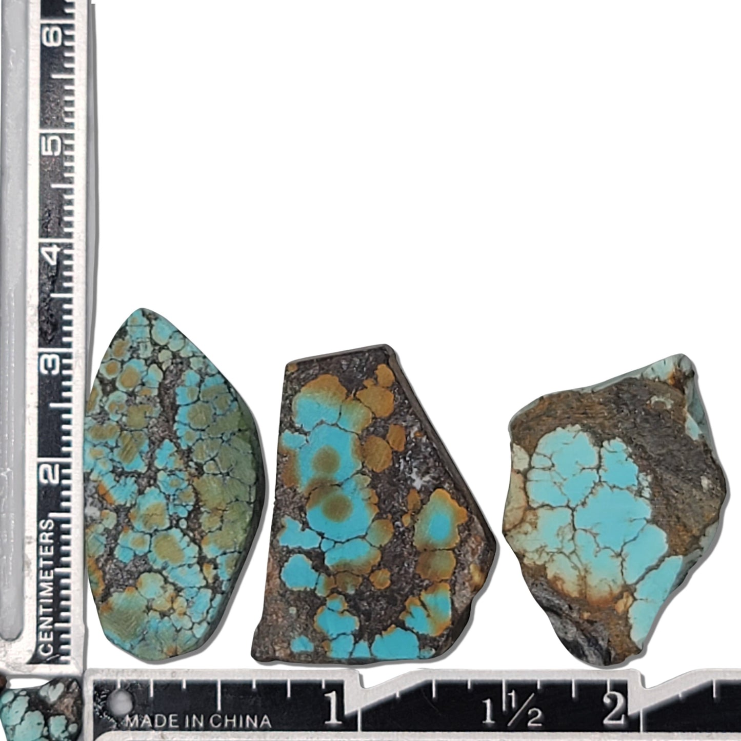 A natural turquoise stone triplet weighing 19 grams, featuring vibrant blue and green tones with golden highlights and bold dark matrix patterns. The stones measure approximately 4 cm x 2.5 cm, 3.8 cm x 2.3 cm, and 3.5 cm x 2.2 cm, displayed with a ruler for scale. Available for purchase at www.naturalturquoise.com, ideal for lapidary and jewelry projects.