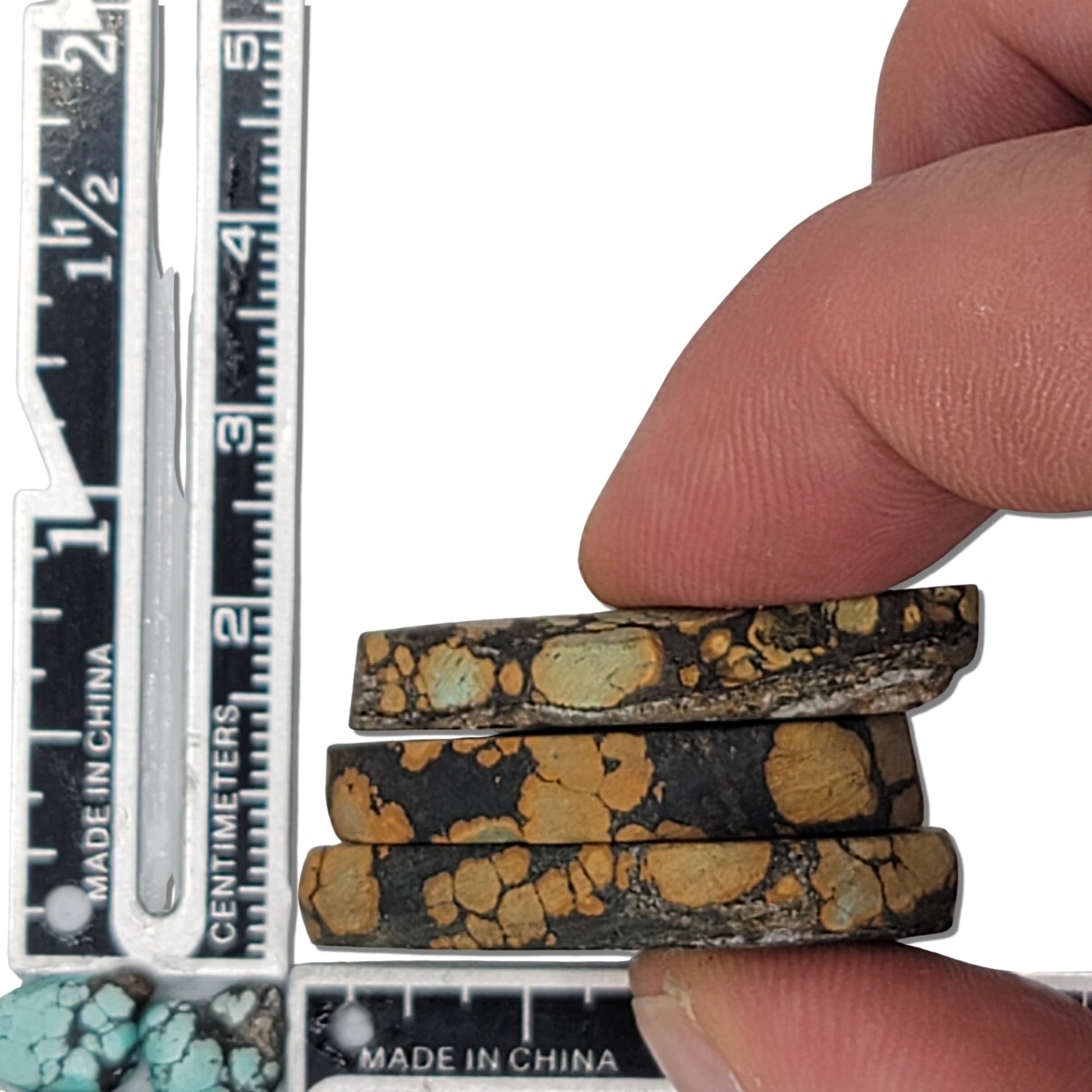 A natural turquoise stone triplet weighing 18 grams, featuring earthy golden tones with green highlights and bold dark matrix patterns. The stones measure approximately 4 cm x 2.5 cm, 3.8 cm x 2.7 cm, and 3.5 cm x 2.5 cm, displayed with a ruler for scale. Available for purchase at www.naturalturquoise.com, ideal for lapidary and jewelry projects.