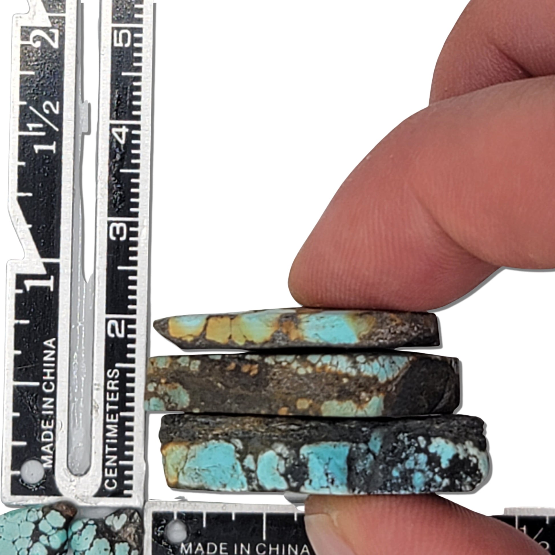 A natural turquoise stone triplet weighing 21 grams, featuring vibrant blue tones with golden accents and bold dark matrix patterns. The stones measure approximately 4 cm x 3 cm, 3.8 cm x 2.8 cm, and 3.7 cm x 2.5 cm, displayed with a ruler for scale. Available for purchase at www.naturalturquoise.com, ideal for lapidary and jewelry projects.






