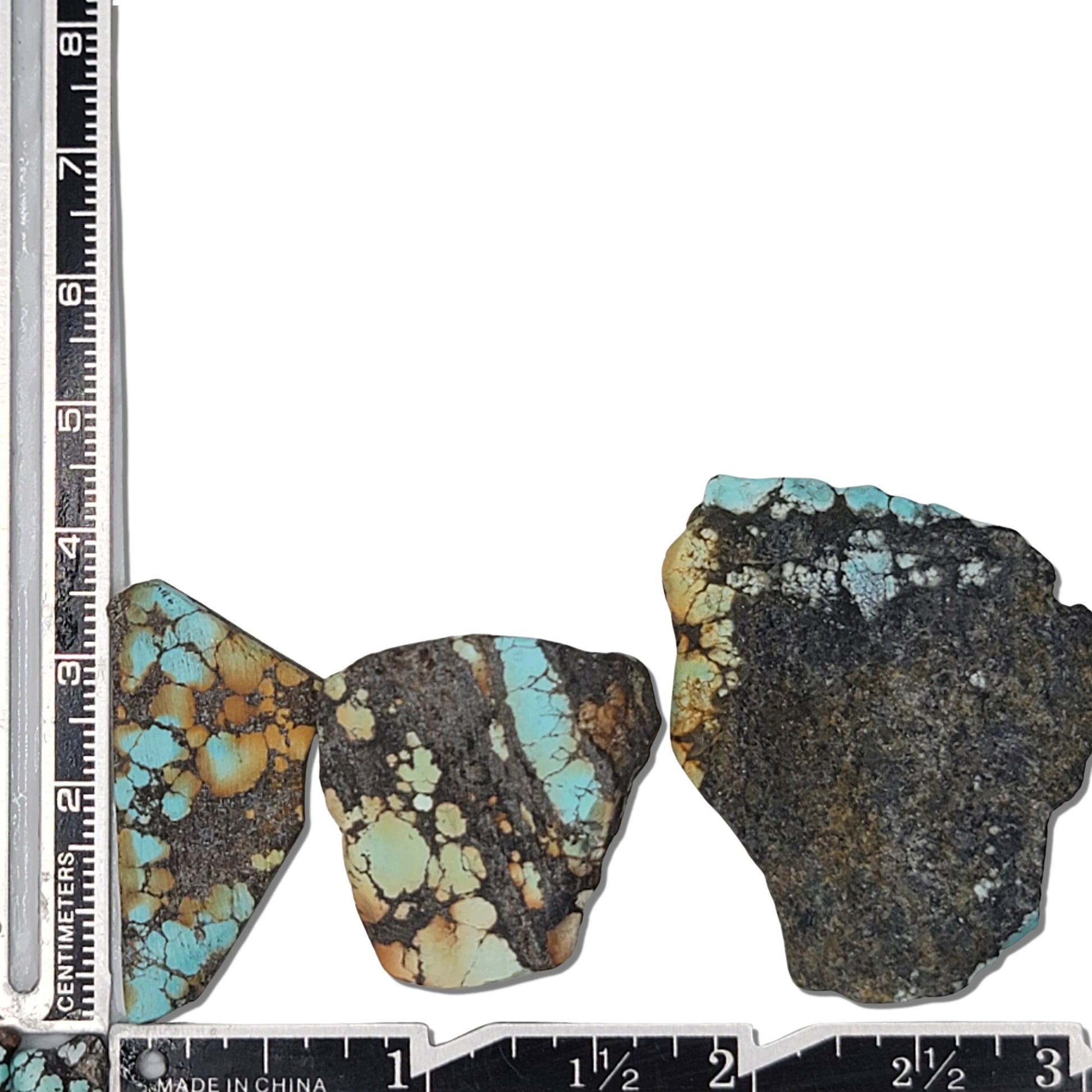 A natural turquoise stone triplet weighing 23 grams, featuring vibrant blue tones with golden accents and bold dark matrix patterns. The stones measure approximately 4.2 cm x 2.7 cm, 3.8 cm x 2.5 cm, and 3.5 cm x 2.8 cm, displayed with a ruler for scale. Available for purchase at www.naturalturquoise.com, ideal for lapidary and jewelry projects.