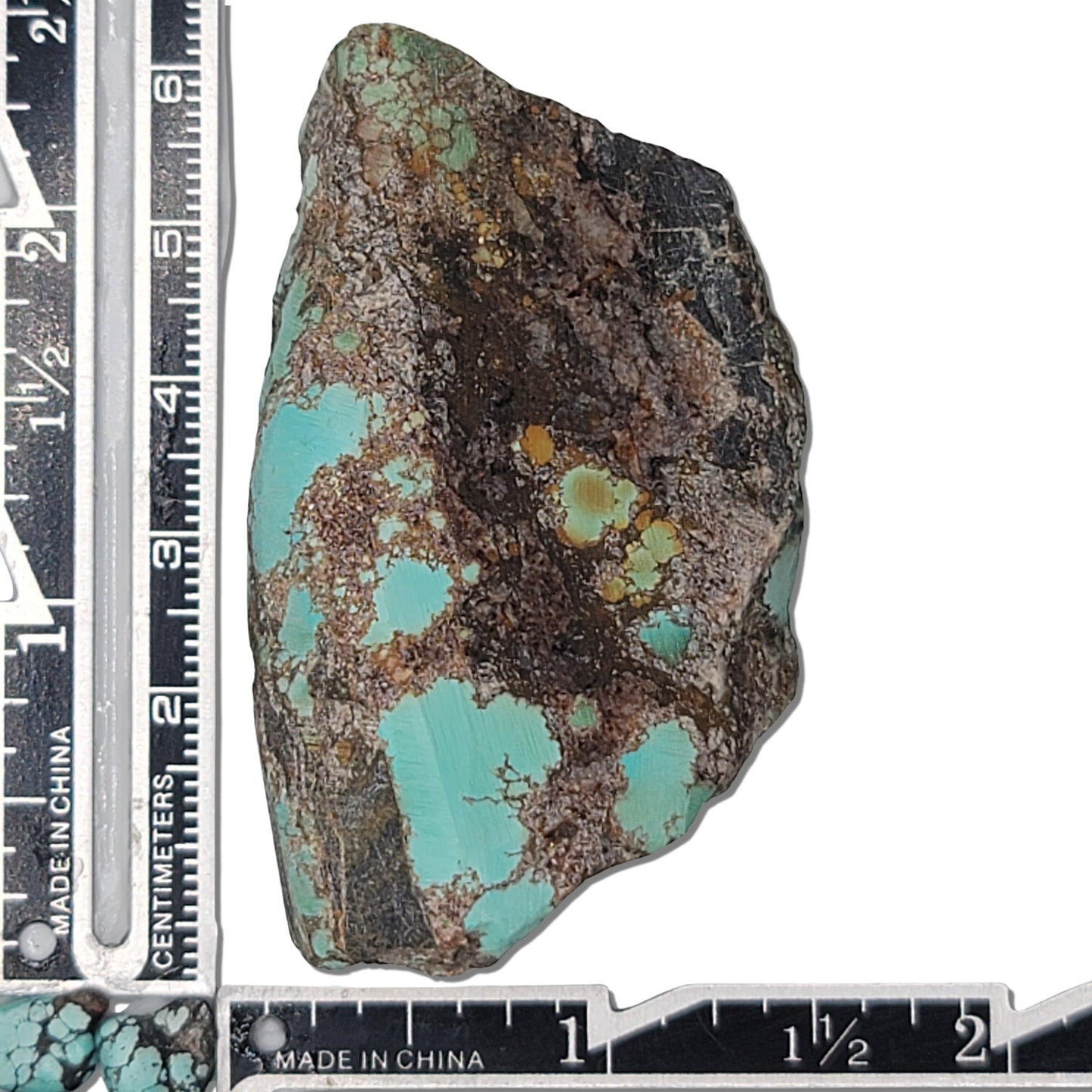 A natural turquoise stone weighing 64 grams, showcasing vibrant blue and earthy brown hues with bold matrix patterns. The stone measures approximately 7 cm x 4.5 cm x 1 cm, displayed with a ruler for scale. Available for purchase at www.naturalturquoise.com, perfect for lapidary and jewelry projects.