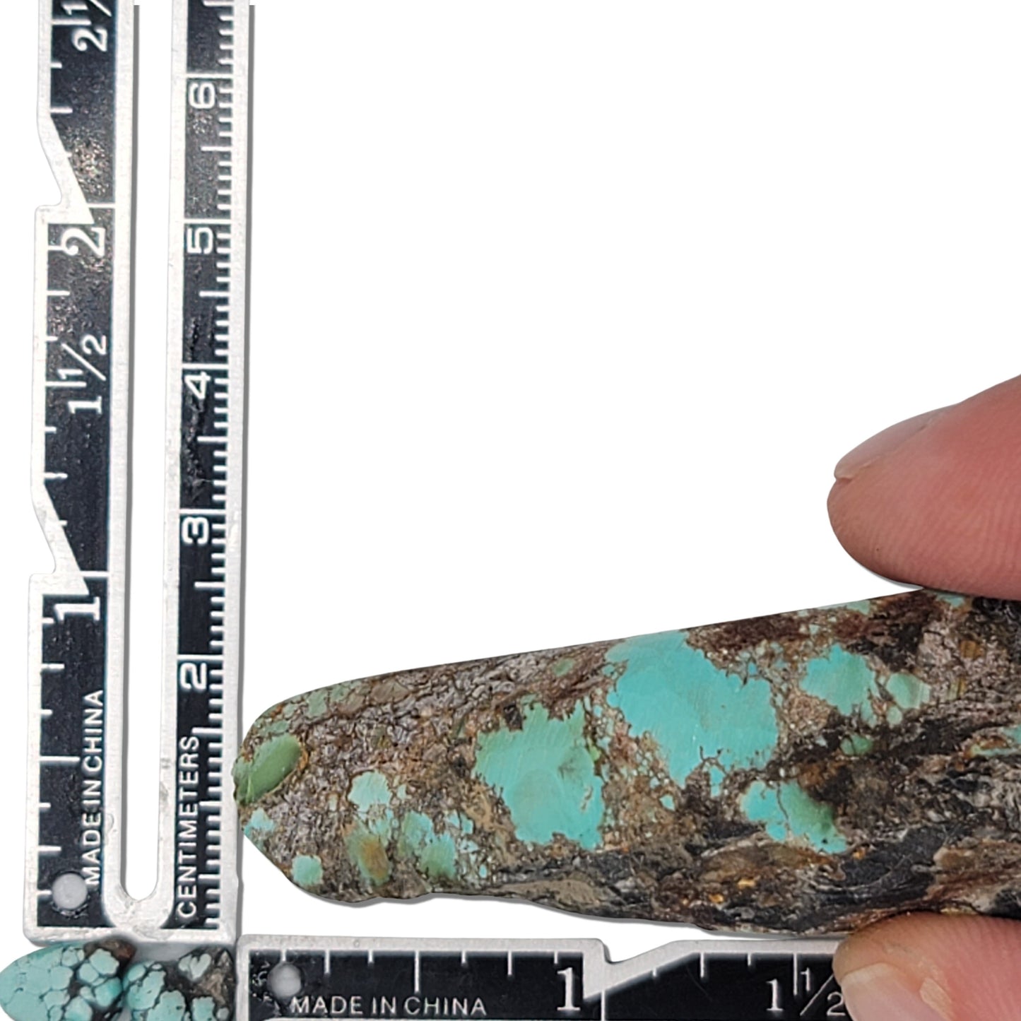 A natural turquoise stone weighing 64 grams, showcasing vibrant blue and earthy brown hues with bold matrix patterns. The stone measures approximately 7 cm x 4.5 cm x 1 cm, displayed with a ruler for scale. Available for purchase at www.naturalturquoise.com, perfect for lapidary and jewelry projects.