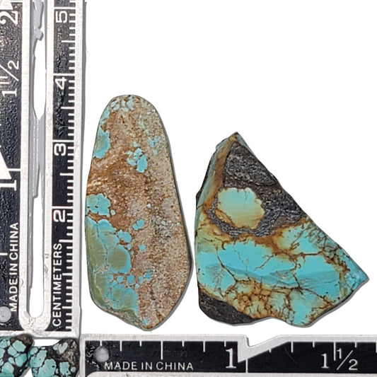 A pair of 17-gram natural turquoise rough stones featuring sky blue hues with brown and gold matrix patterns. The largest stone measures approximately 4.0 cm x 2.0 cm x 0.6 cm. Ideal for jewelry design or lapidary projects, available at www.naturalturquoise.com.






